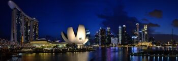 Singapour : Marina Bay de nuit avec gratte-ciels illuminés.